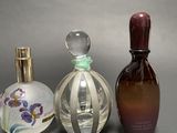 three bottles of perfume sitting next to each other on a table