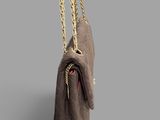 a brown bag with a gold chain hanging from it ' s side
