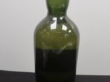 une bouteille vide bouchée, posée sur une table noire