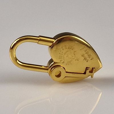 a close up of a gold padlock on a white surface