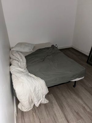 un lit situé dans une petite chambre avec du parquet
