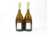 deux bouteilles de vin posées l'une à côté de l'autre sur une surface blanche