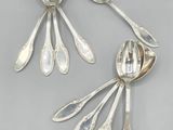 une paire de cuillères en argent et des cuillères posées sur une table