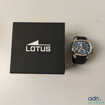 La montre est posée sur la boîte, à côté de sa propre boîte.