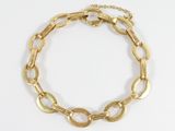 gros plan d'un bracelet en or sur fond blanc