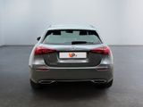 the rear end of a silver car in a white room