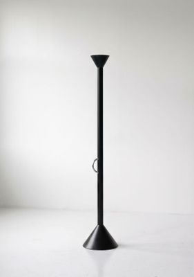 une image représentant un bougeoir noir posé sur une surface blanche