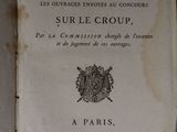 un vieux livre posé sur une table à côté d'un mur