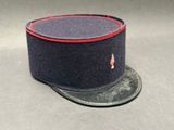 chapeau bleu marine orné de galons rouges sur fond gris