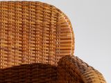 a wicker chair that is sitting on a white surface