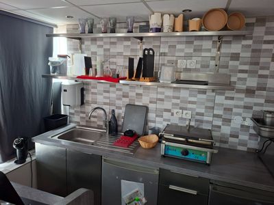 une cuisine équipée d'un évier, d'une cuisinière, d'un micro-ondes et d'une fenêtre
