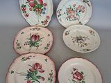 several plates with floral designs on them sit on a table