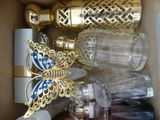 a box full of glass bottles and a gold butterfly
