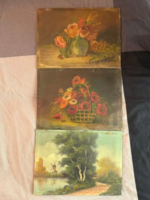 trois tableaux représentant des fleurs dans un panier posé sur un lit