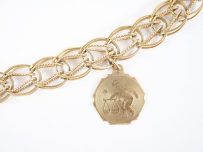 une image représentant un bracelet en chaîne d'or orné d'une pièce de monnaie