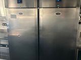 deux réfrigérateurs en acier inoxydable dans une cuisine, à côté d'une cuisinière