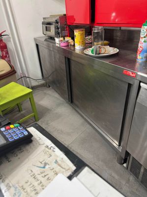 a kitchen with stainless steel counter tops and red cabinets