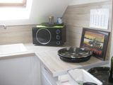 a small kitchen with a sink and a microwave on the counter