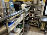 de nombreuses casseroles et poêles sur les étagères de la cuisine