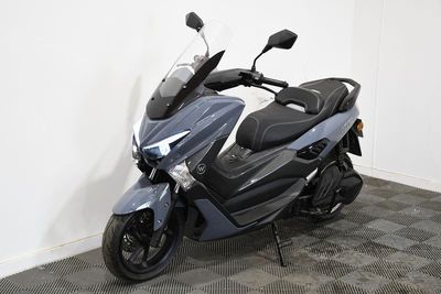 une moto garée dans une pièce au sol à carreaux