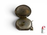 an old pocket watch sitting on top of a white surface