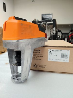 une agrafeuse à main orange et noire posée à côté d'une boîte