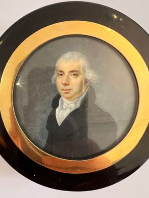 portrait d'un homme vêtu d'un manteau noir, avec un collier doré autour du cou