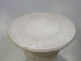 a white vase sitting on top of a glass table