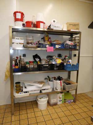 une cuisine équipée d'une cuisinière, d'étagères et d'un réfrigérateur