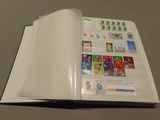 an open book with stamps on it sitting on a table