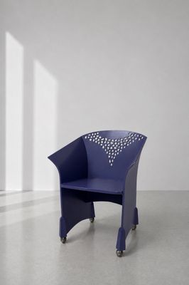 une image représentant une chaise bleue dans une pièce aux murs blancs