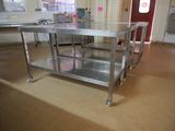 a stainless steel table in the middle of a kitchen