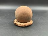 a clay ball on a wooden stand on a table