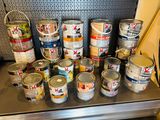de nombreux pots de peinture posés sur une étagère dans un magasin