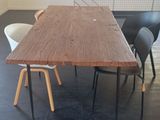 une table en bois entourée de quatre chaises dans une pièce