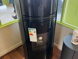 a black refrigerator in the corner of a room next to a table