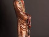 an old statue of a man with a hat and robe