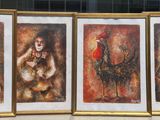 quatre tableaux encadrés posés sur le rebord d'une fenêtre devant un immeuble