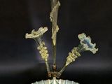 une photo représentant un vase en verre contenant des fleurs, posé sur une table