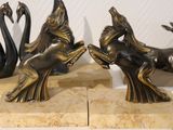 three bronze statues of animals on a marble base