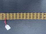a close up of a gold bracelet with a tag on it