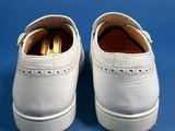 pair of white shoes on a blue surface with a blue background