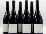 six bottles of wine are lined up in a row on a white surface