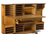an image of a wooden desk with shelves and drawers