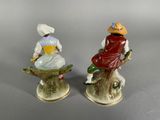 two figurines of a man and a woman sitting on a tree stump