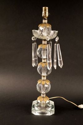 une lampe de table en verre avec un pied doré et un abat-jour en verre transparent