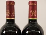 two bottles of wine sitting next to each other on a table
