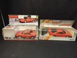 two red toy cars are sitting side by side on a black surface