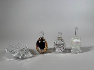 three glass perfume bottles sitting next to each other on a white surface