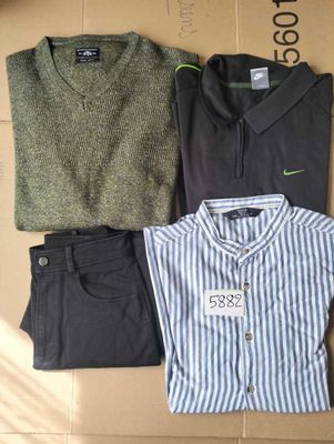 trois chemises et pantalons pour homme posés sur une boîte en carton